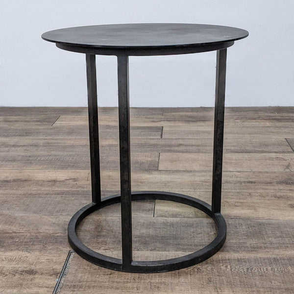 Restoration Hardware black metal side table with round top and base.