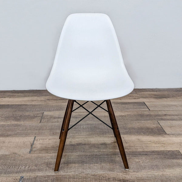 a mid century modern chair with a white plastic frame and a black base.