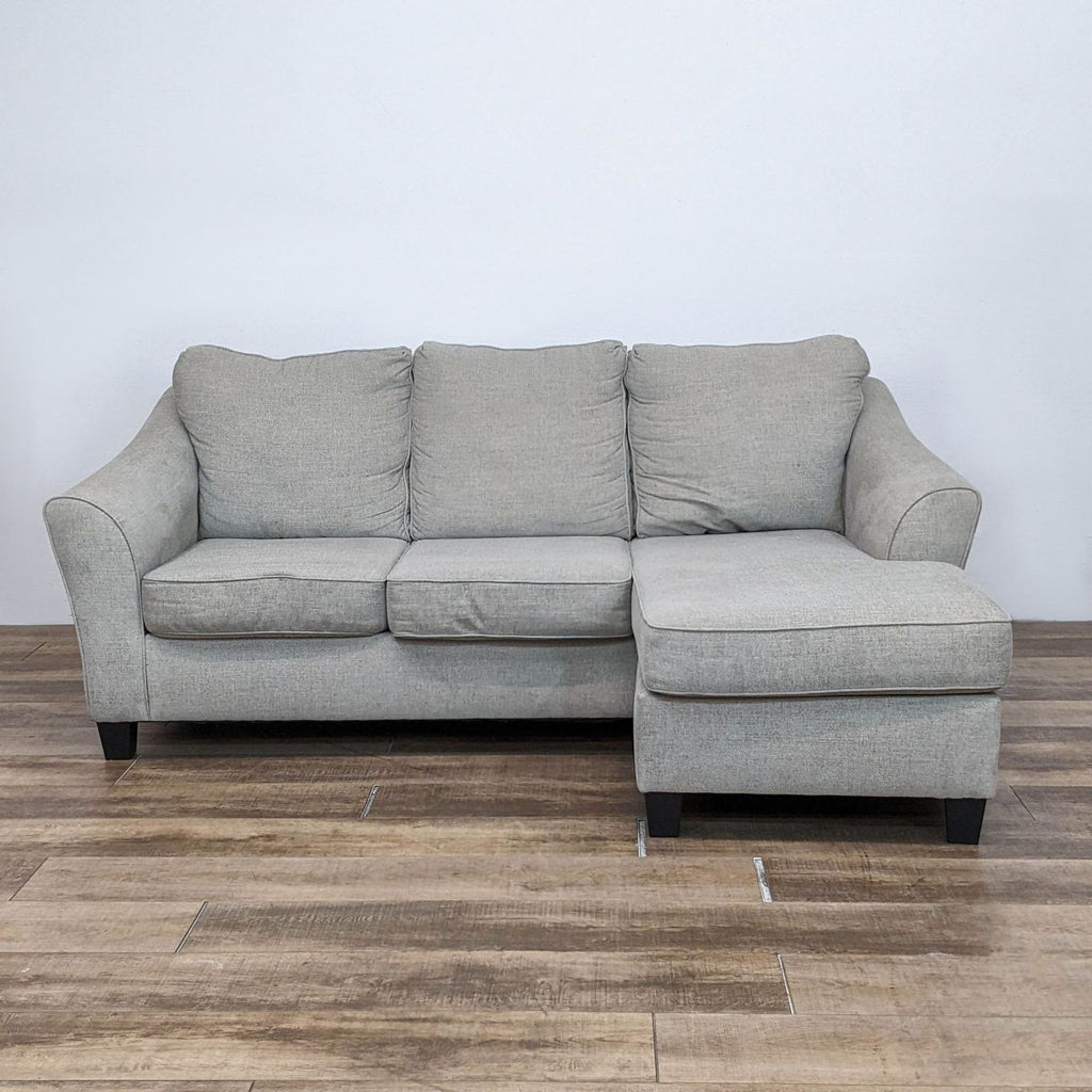 Driftwood fabric sofa with chaise, flared arms, and dark finish feet.