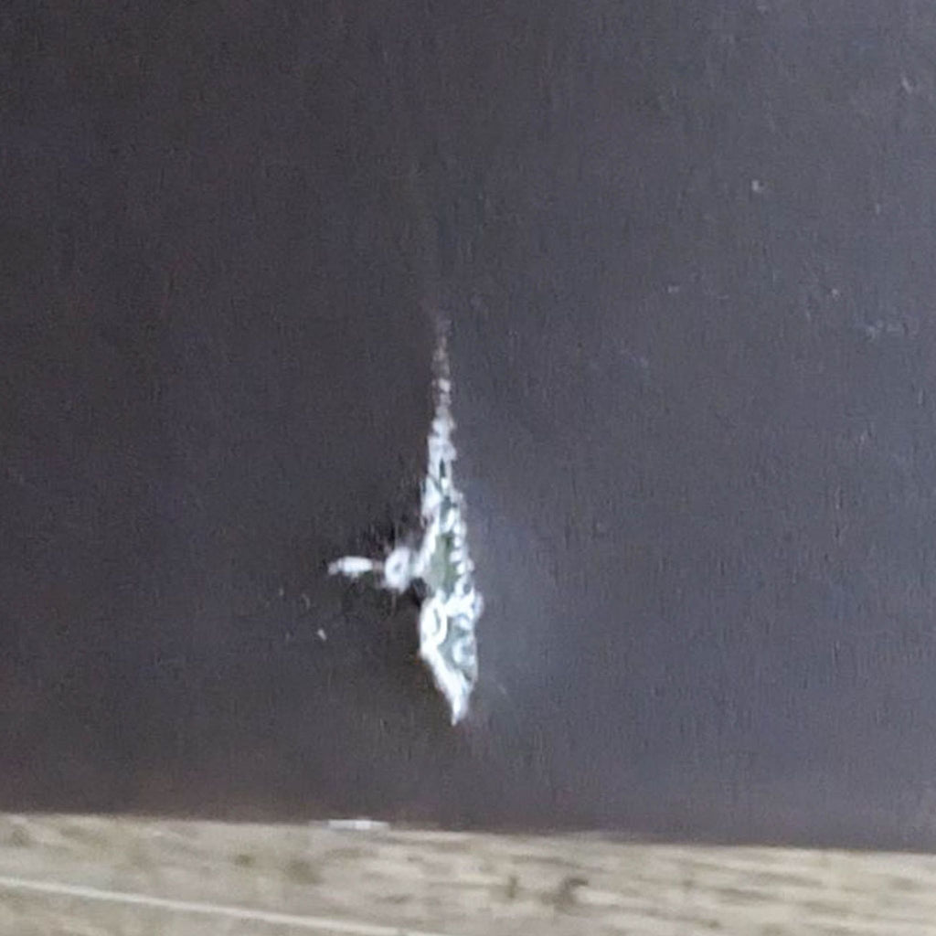 Close-up of a tear in the brown leather-look material.