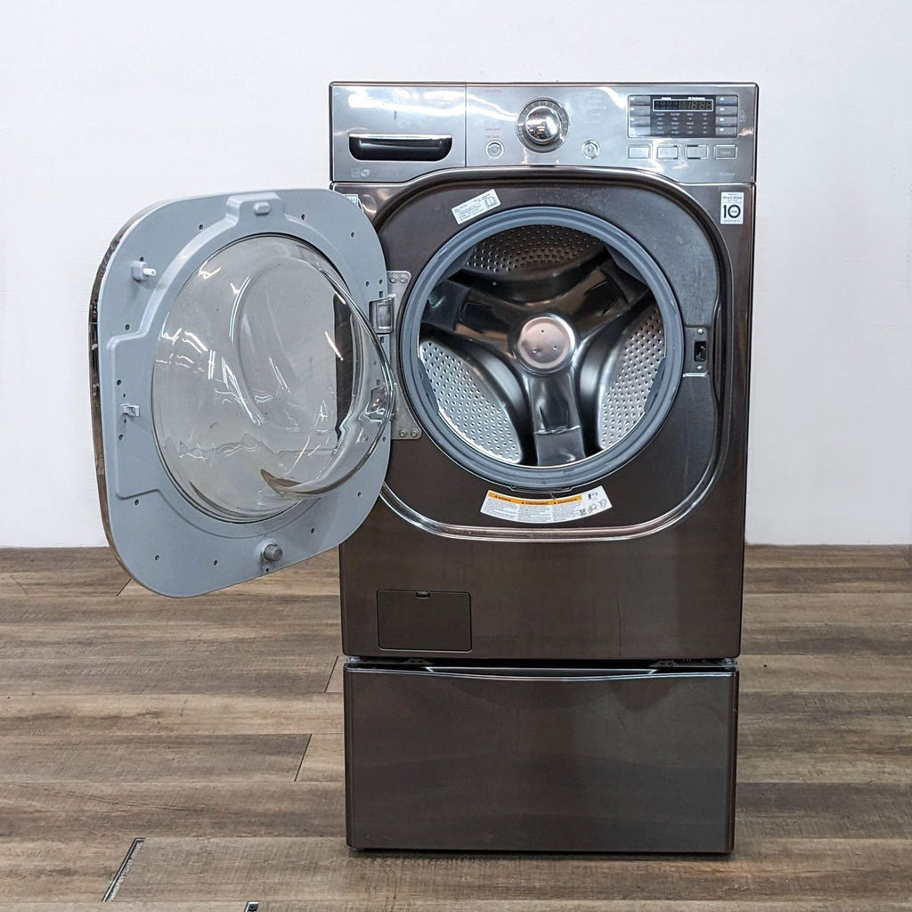 LG washer/dryer with open door showing drum interior on hardwood floor.
