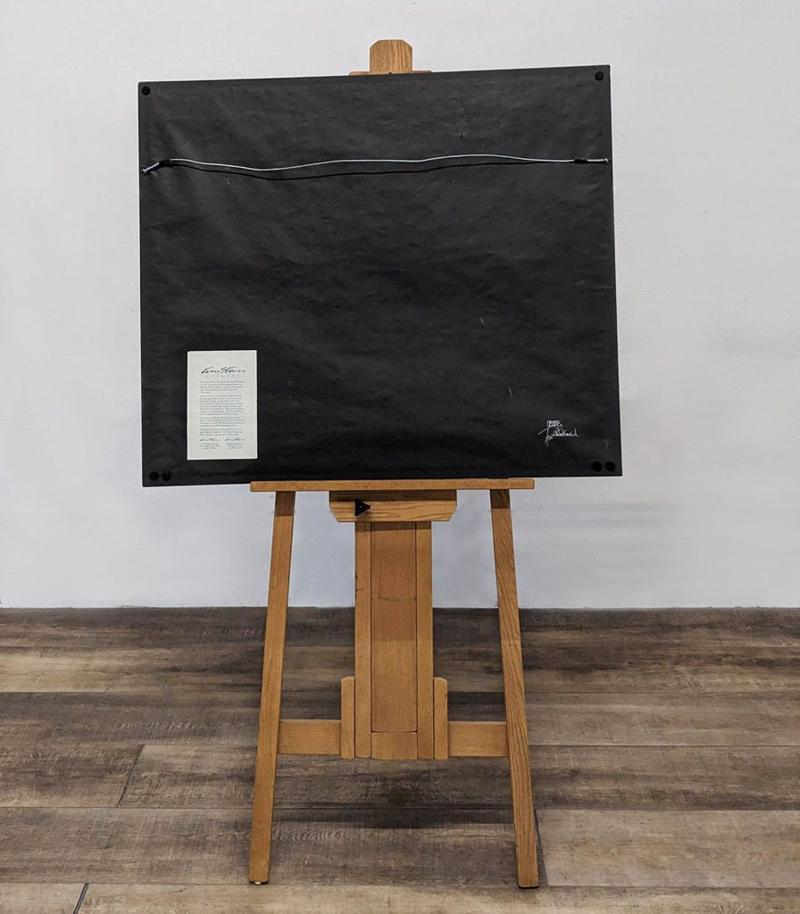 Back view of a framed print on easel with a hanging wire and label. Brand: Reperch.