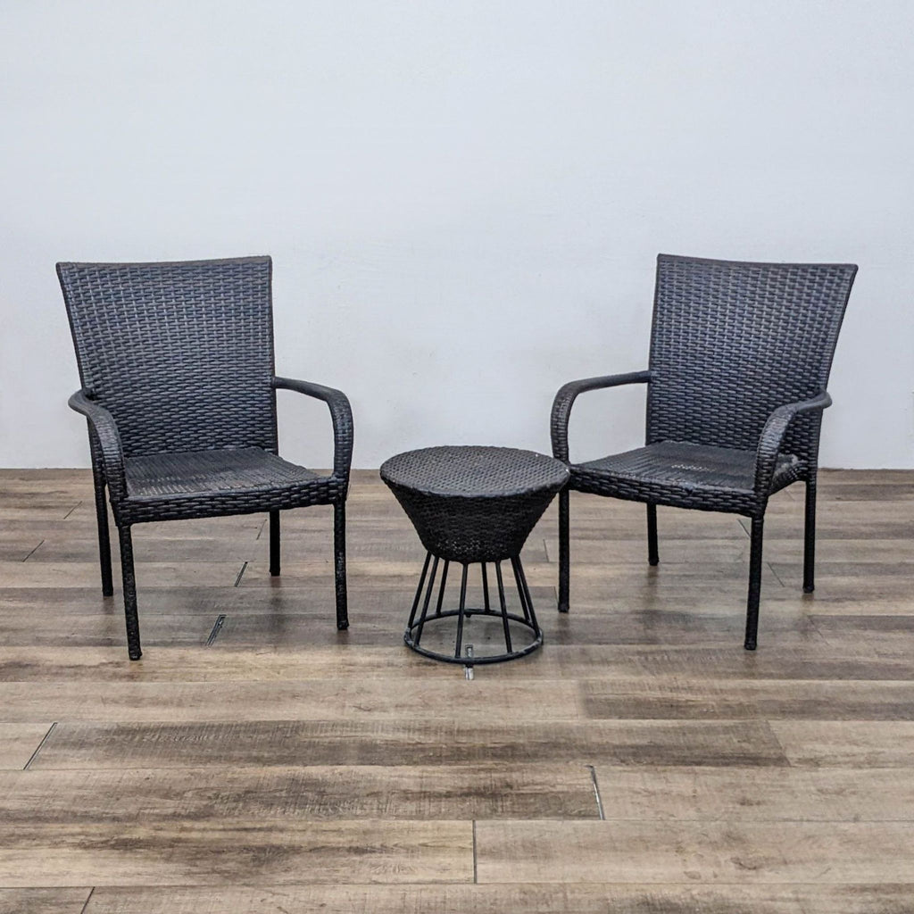 Woven plastic rattan table and two armchairs set on wooden floor.