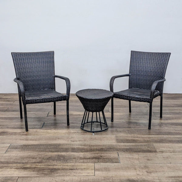 Woven plastic rattan table and two armchairs set on wooden floor.