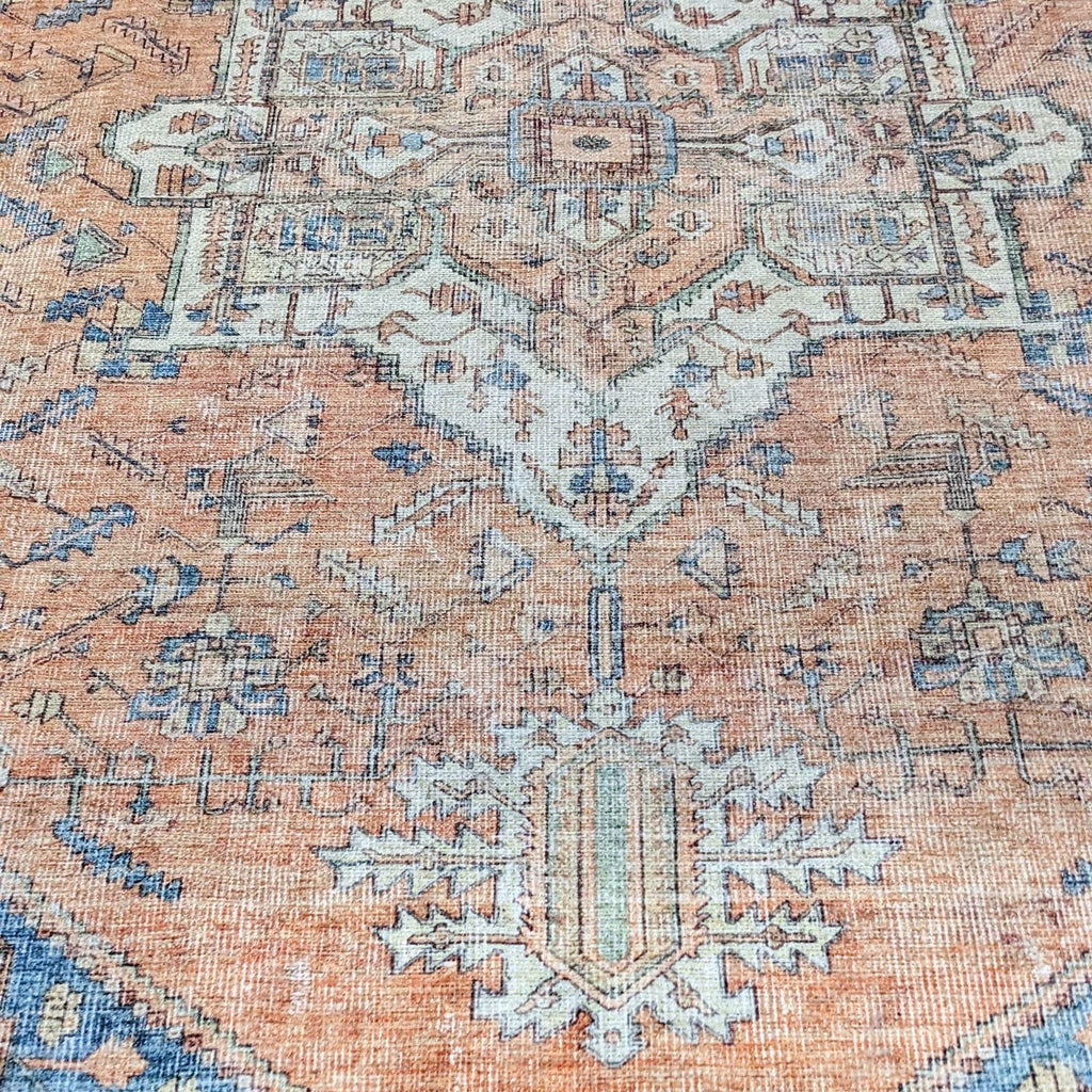 Stain-resistant Persian rug with a blend of orange and blue hues, showcasing central pattern.