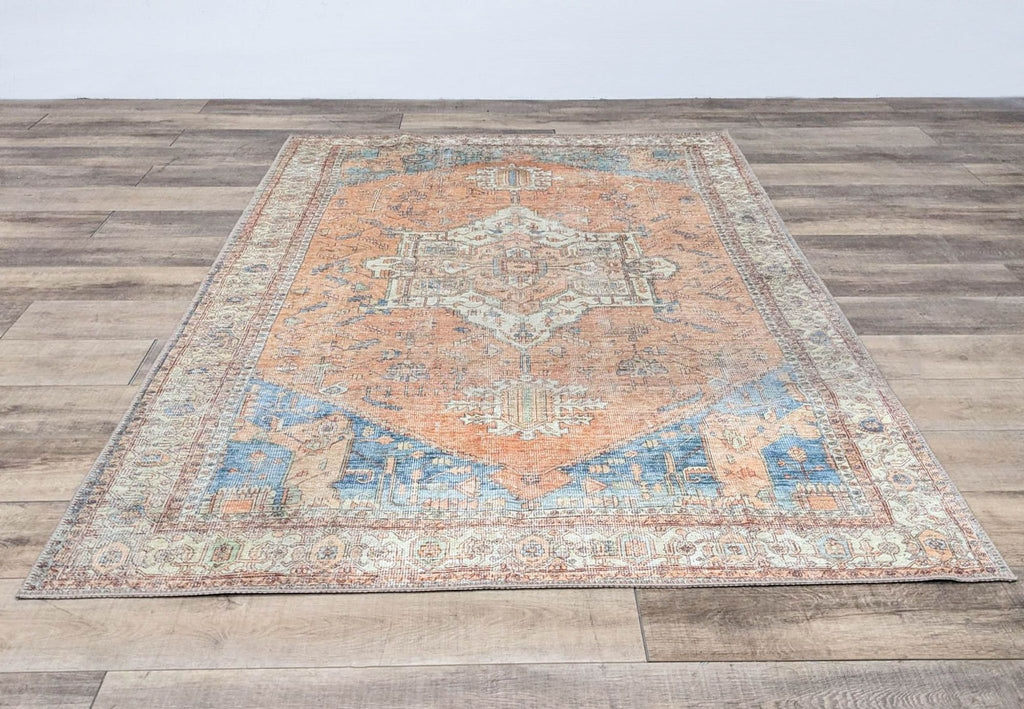 Reperch Persian area rug, 6'x9', with intricate geometric patterns in orange and blue tones.