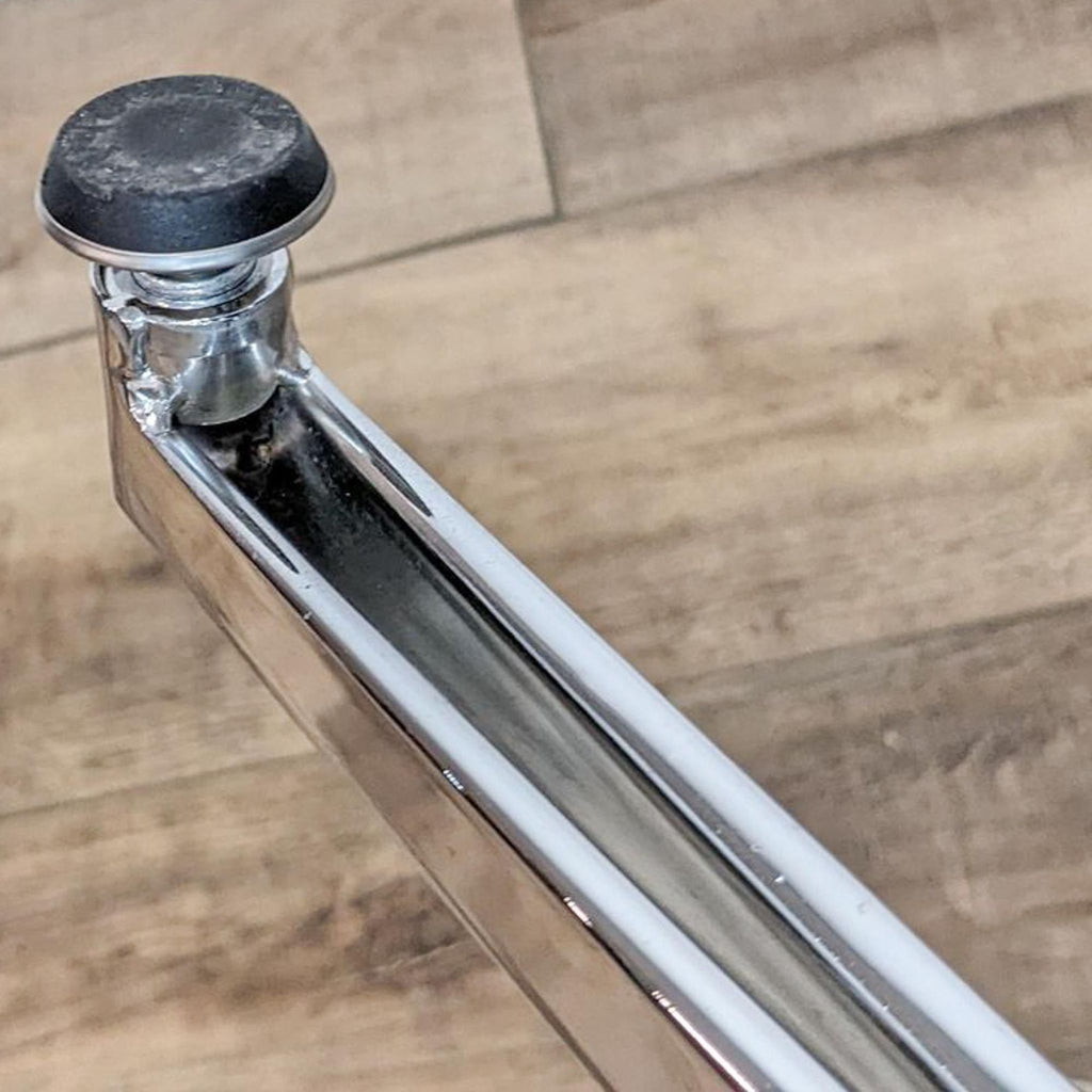Close-up of chrome swivel base on the Reperch armchair.