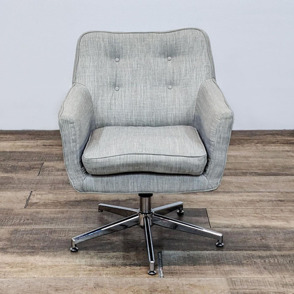 Front view of a linen armchair with button tufting and chrome swivel base.