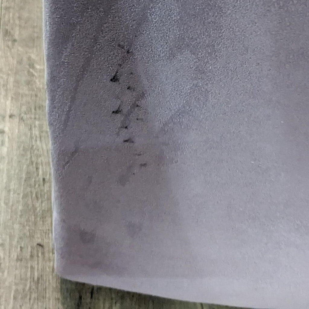 Close-up of the chair's upholstered fabric with slight marks.