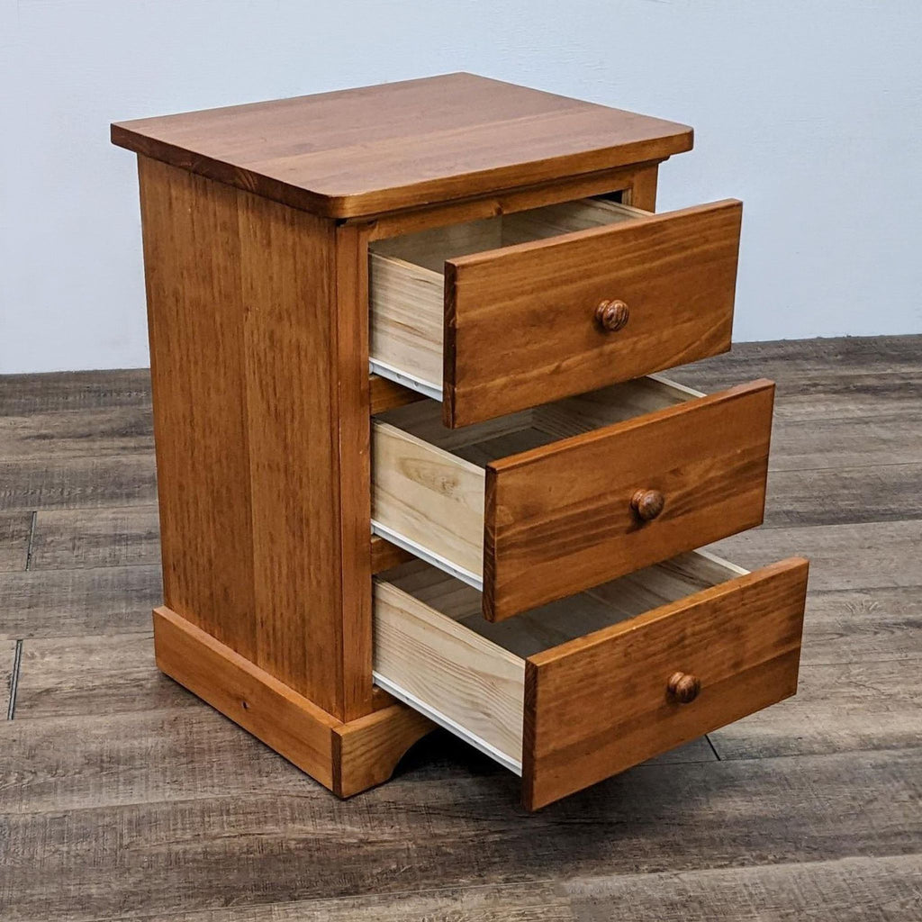 Open drawers of a cinnamon-stained pine end table by Hoot Judkins.  