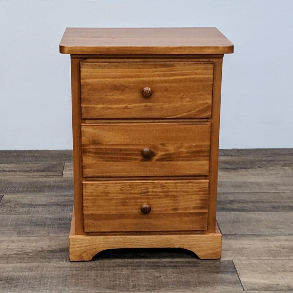 Solid pine end table with three drawers in a cinnamon stain.  