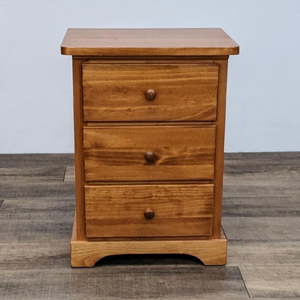 Solid pine end table with three drawers in a cinnamon stain.  