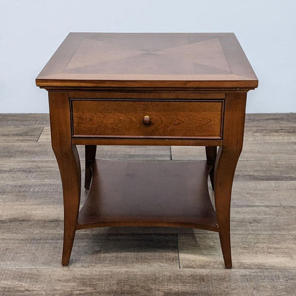Thomasville wooden end table with a drawer and lower shelf. Elegant design and warm finish.