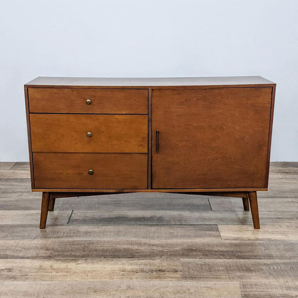 Mid-century modern entertainment center with three drawers and a cabinet.