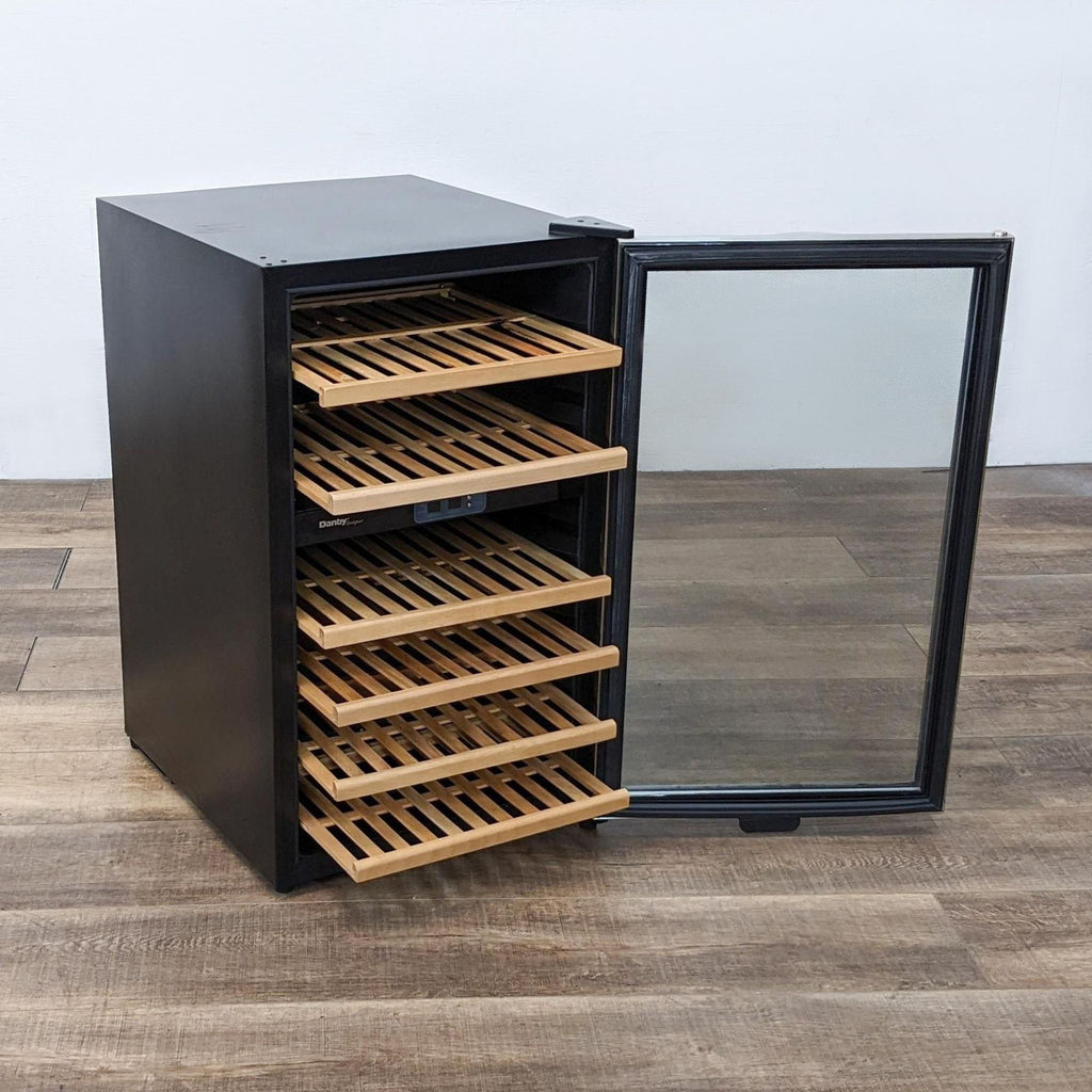 Danby fridge with open door, revealing wooden shelves on a hardwood floor.