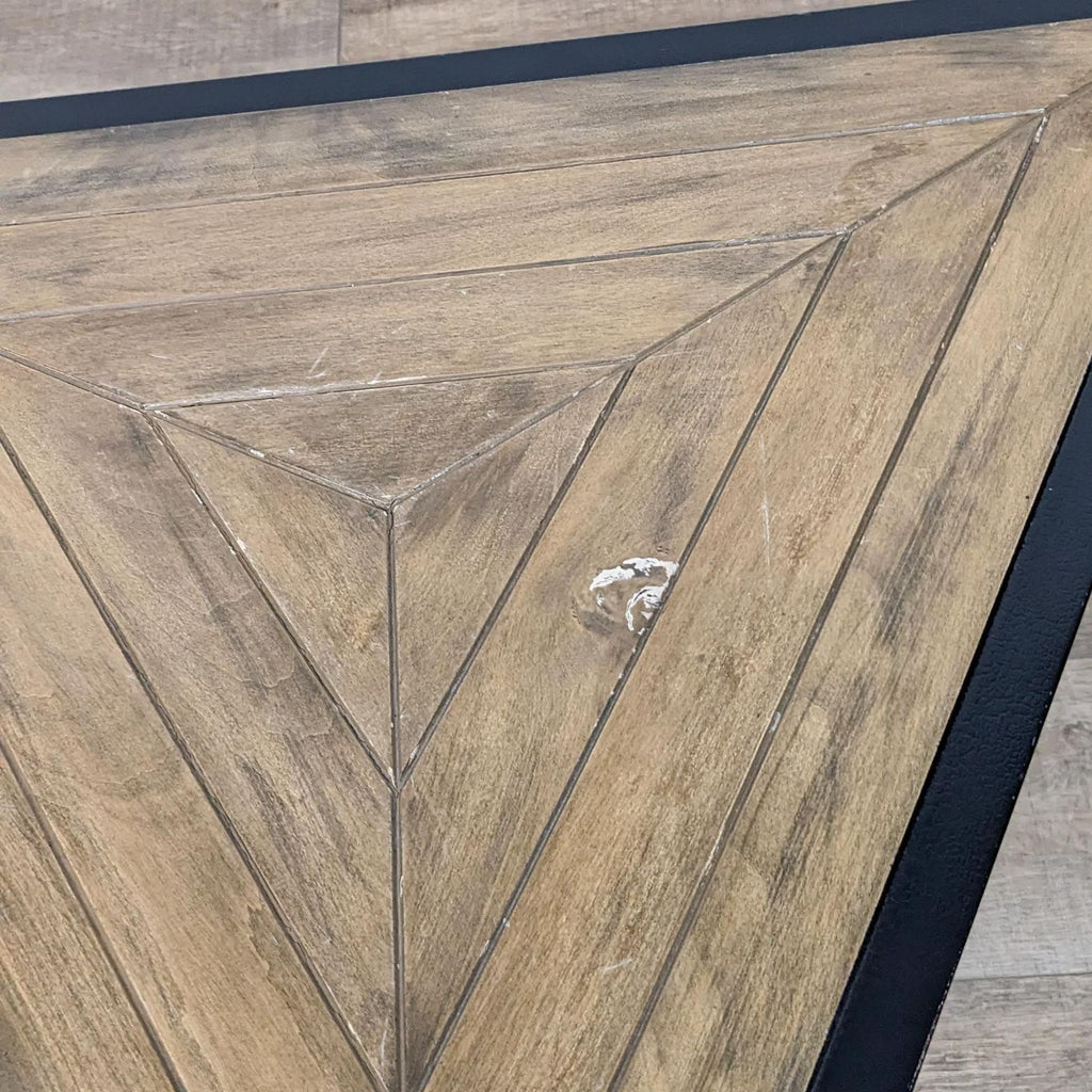 Close-up of the Reperch table’s wooden triangular pattern with detailed trim.