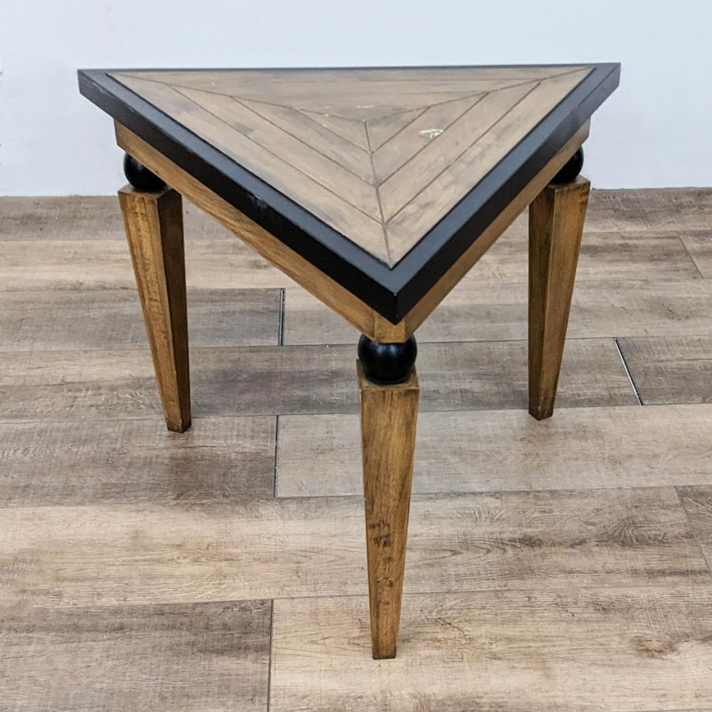 Side view of a Reperch wooden table with a distinctive triangular design and black accents.