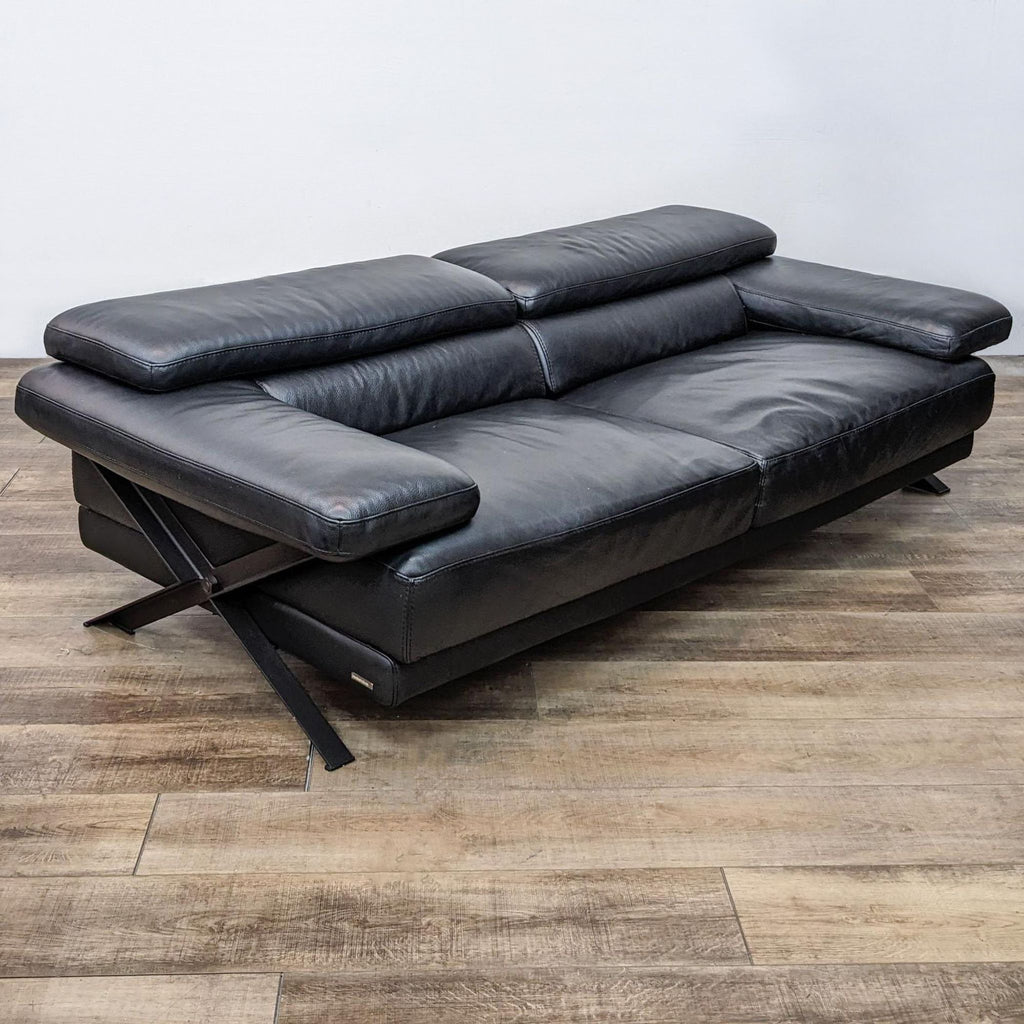 Black leather loveseat with metal side frame and adjustable headrests.