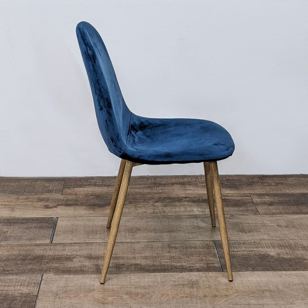 Side view of Reperch velvet dining chair with contoured seat and wooden legs.