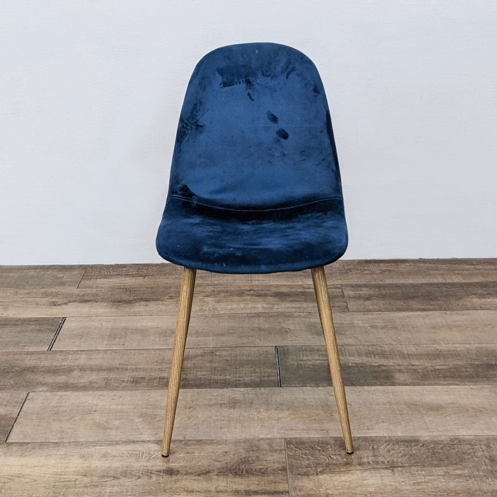Mid-century modern velvet dining chair with tapered wood legs, front view.