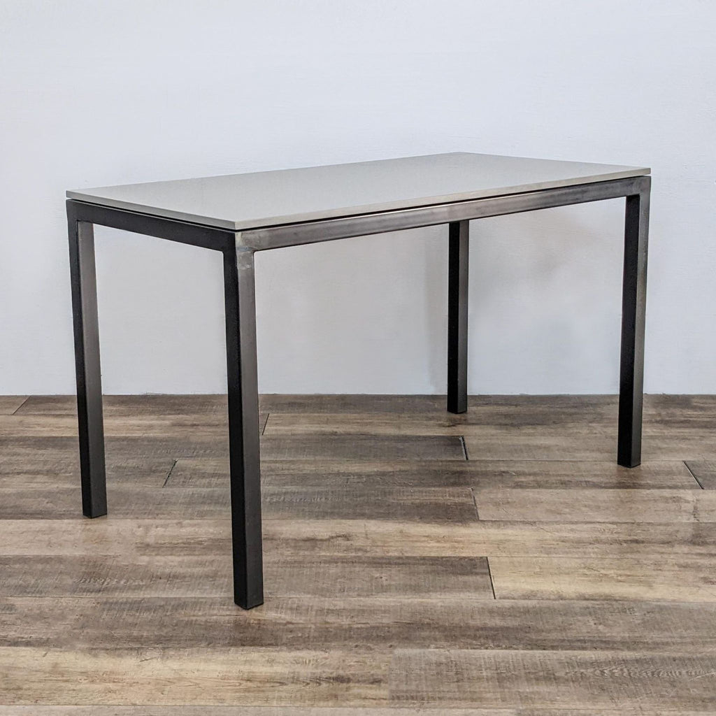 Side view of a modern dining table with steel legs and quartz top.  