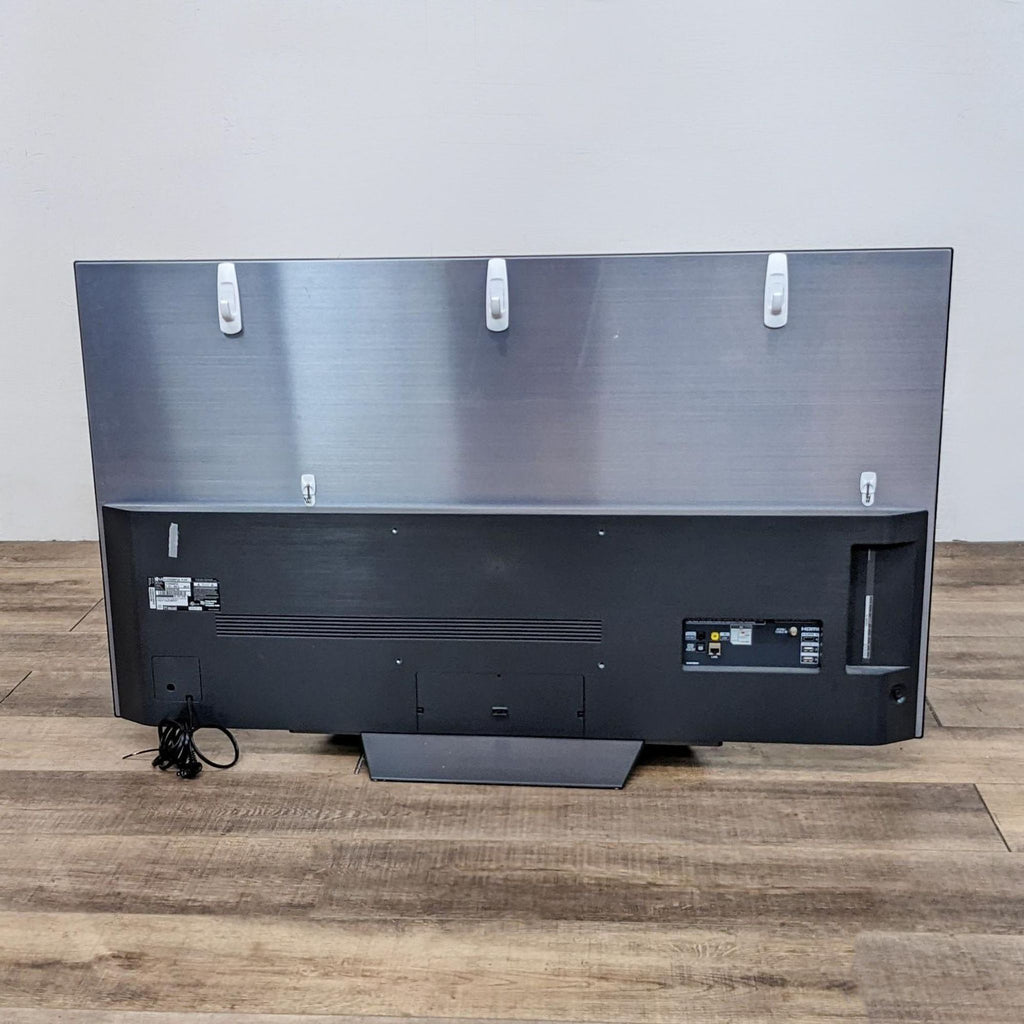 Back view of an LG TV with visible ports and cables.