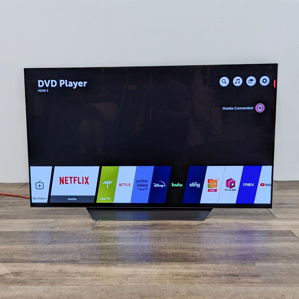 LG TV displaying various streaming app icons on the screen.