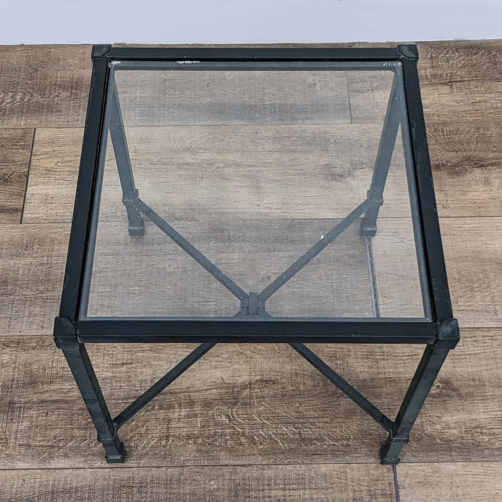 a pair of industrial style metal and glass side tables.