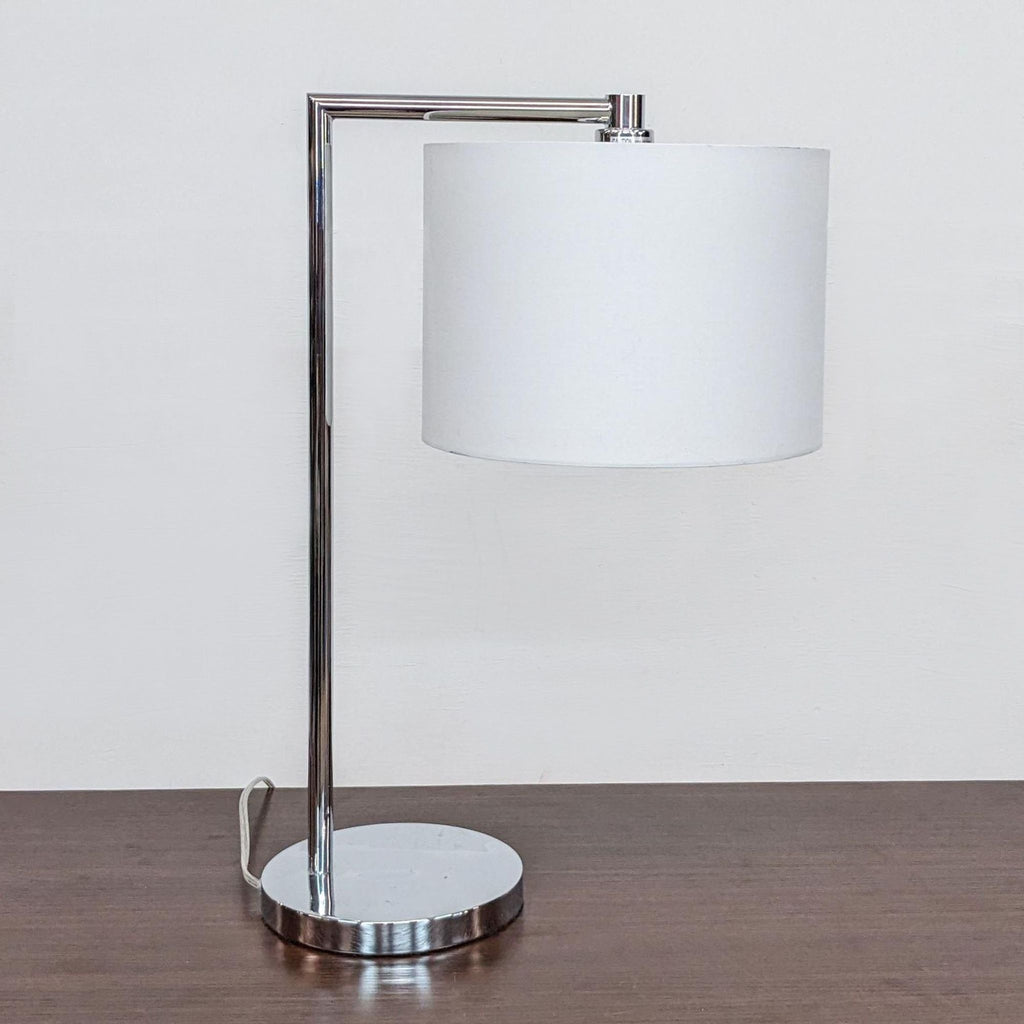 Sleek chrome and white lamp by Zuo Modern, featuring a cylindrical shade and sturdy base.