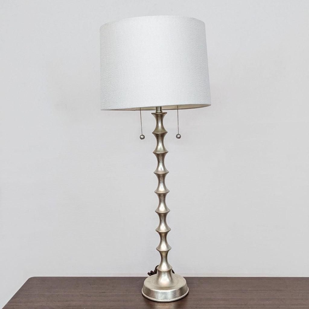 Reperch table lamp with a textured metallic stem and white lampshade.