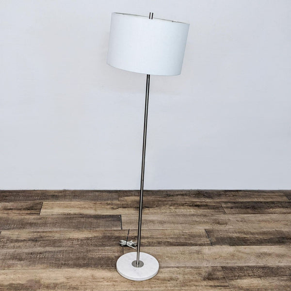 Floor lamp with a sleek metal stand and white lampshade by Reperch.