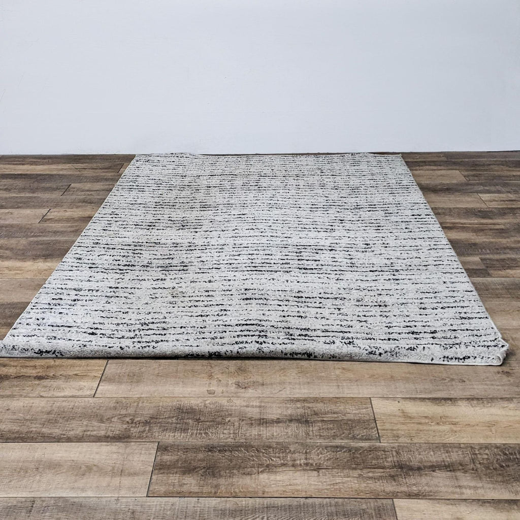 Adirondack rug with ivory and silver linear design on wood floor.