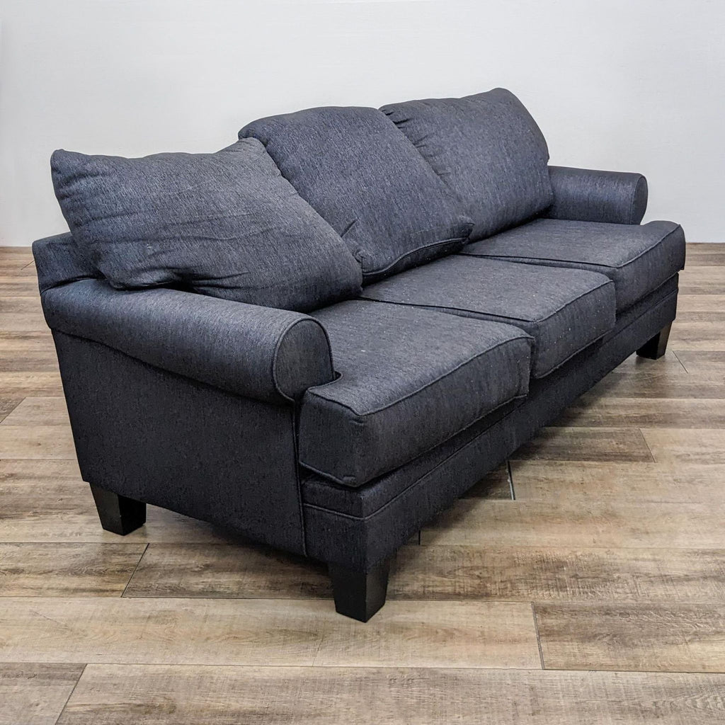 Angled side view of a 3-seat sofa with plush cushions and roll arm design.