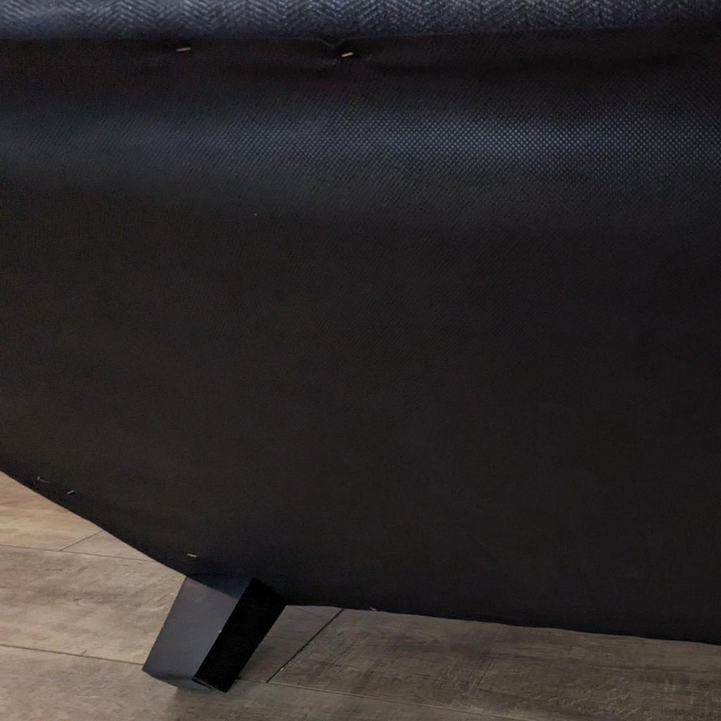Close-up of dark finish feet on a contemporary 79" roll arm sofa.