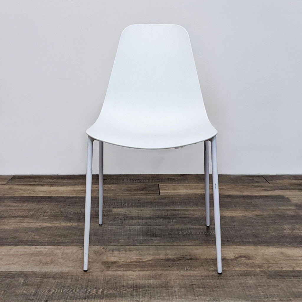 1. White Reperch dining chair with a scooped polypropylene seat and slender metal legs, shown from the front.