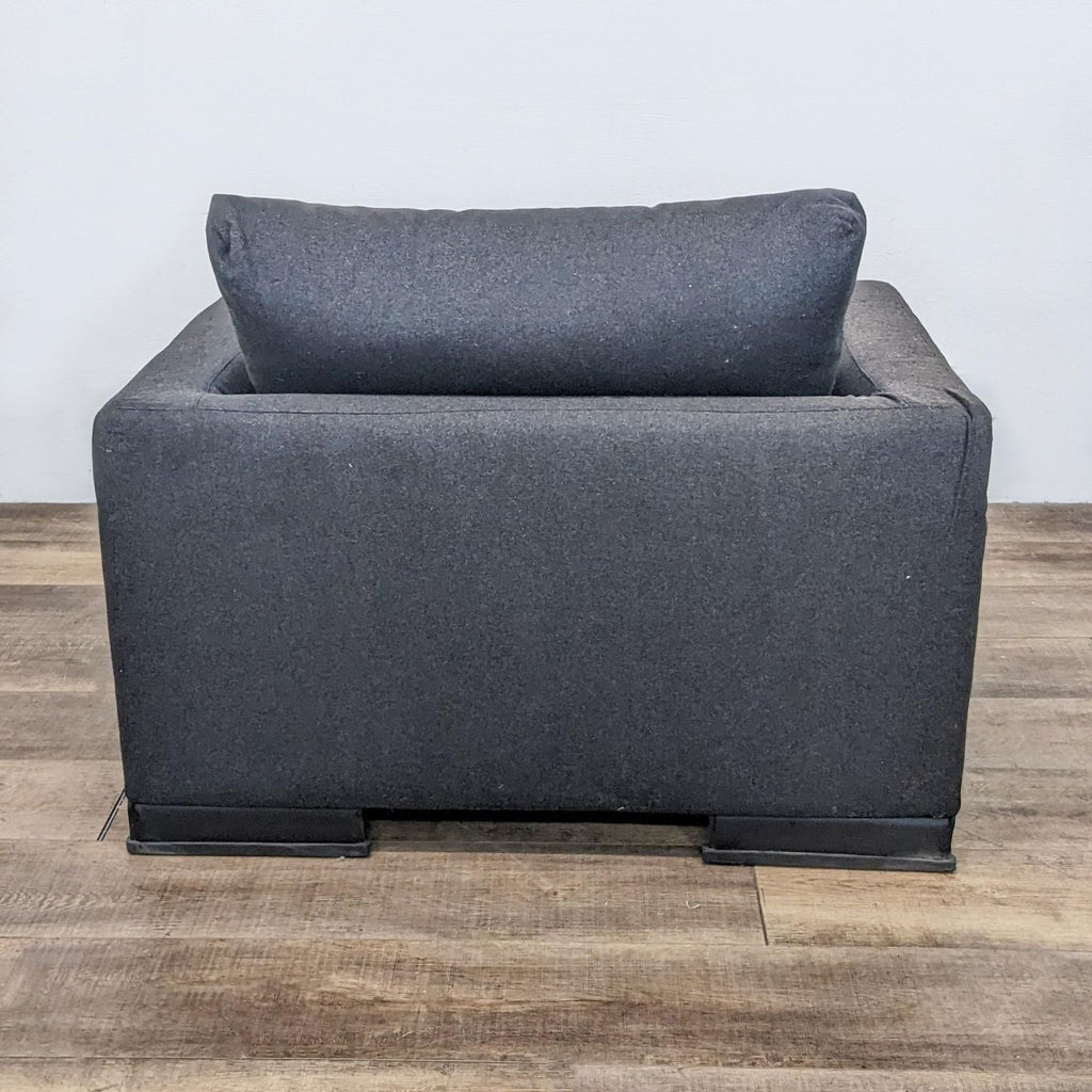 Rear view of the Easytime Chair highlighting the darkened steel legs and cushion detail.