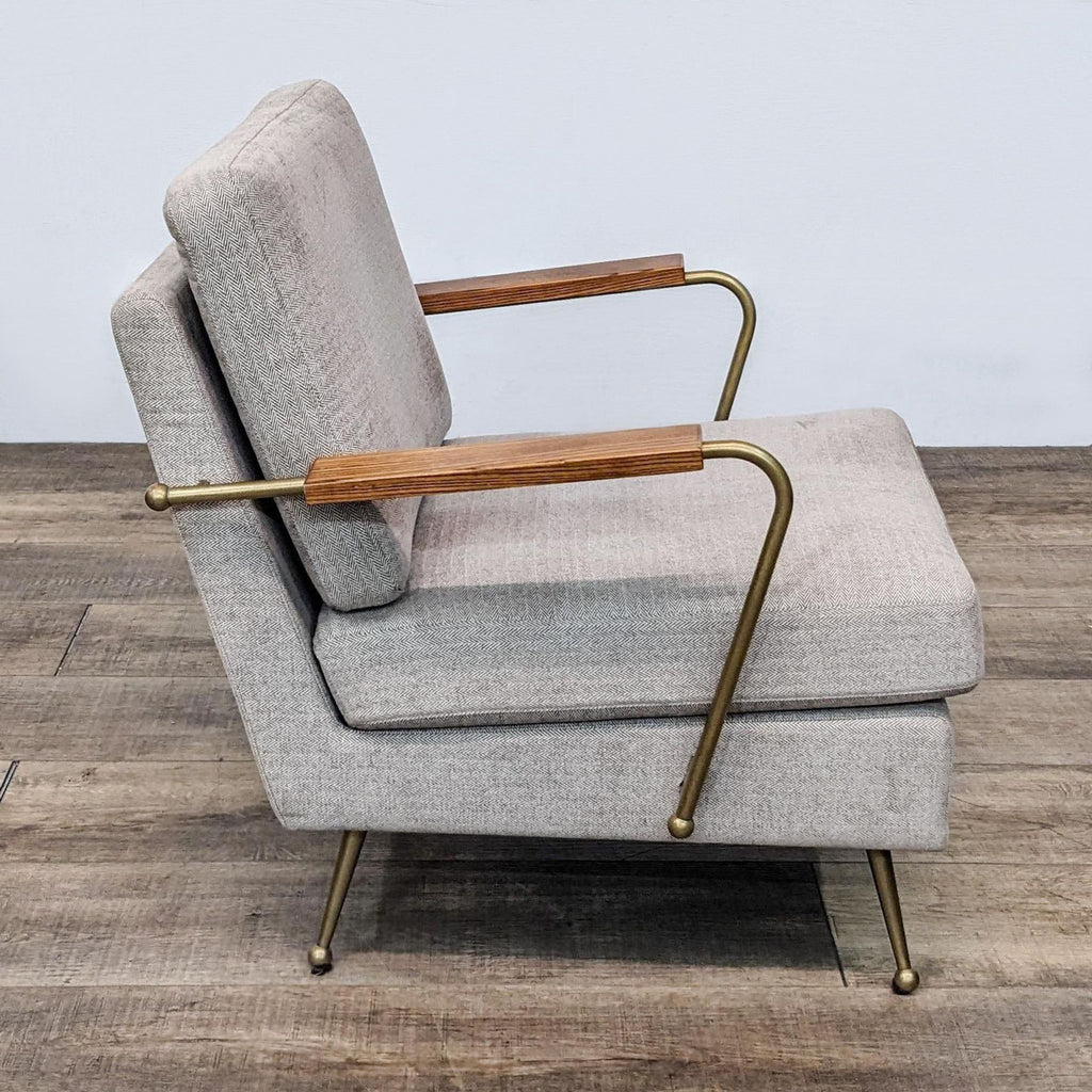 Side view of an MXM accent chair with textured fabric and brass legs.
