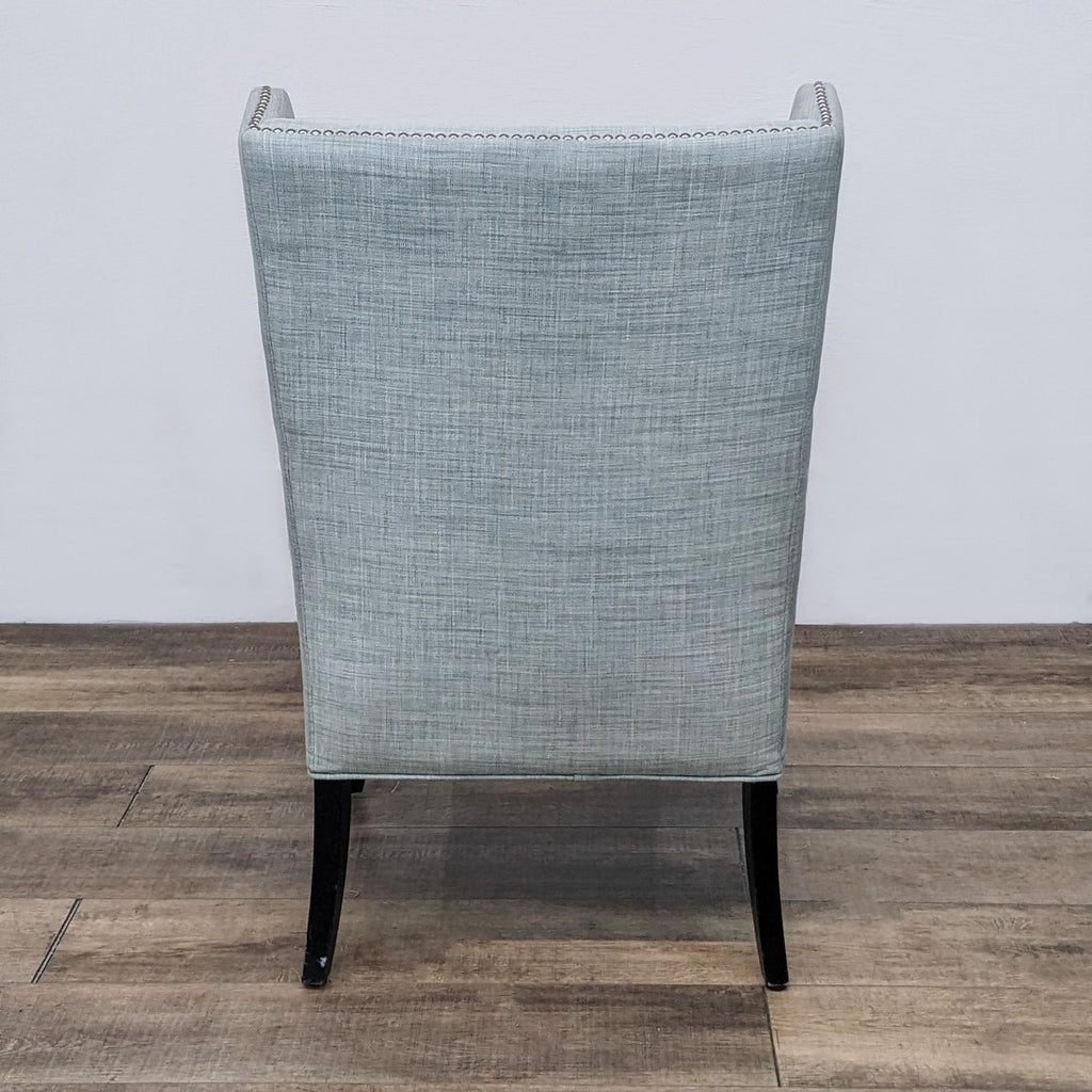 Rear view of a lounge chair showcasing its fabric and elegant wood legs.