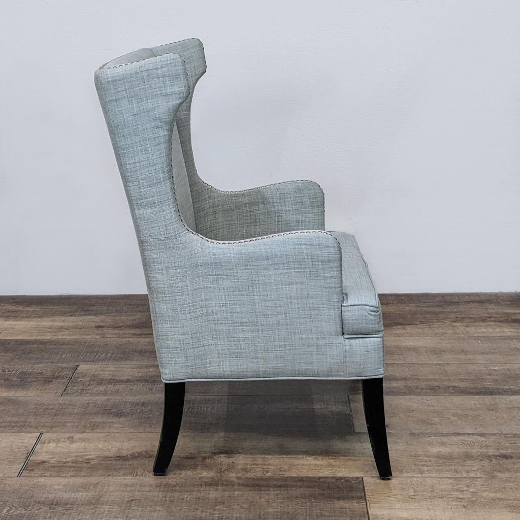 Side view of a curved-arm chair upholstered in omen fabric with a classic design.