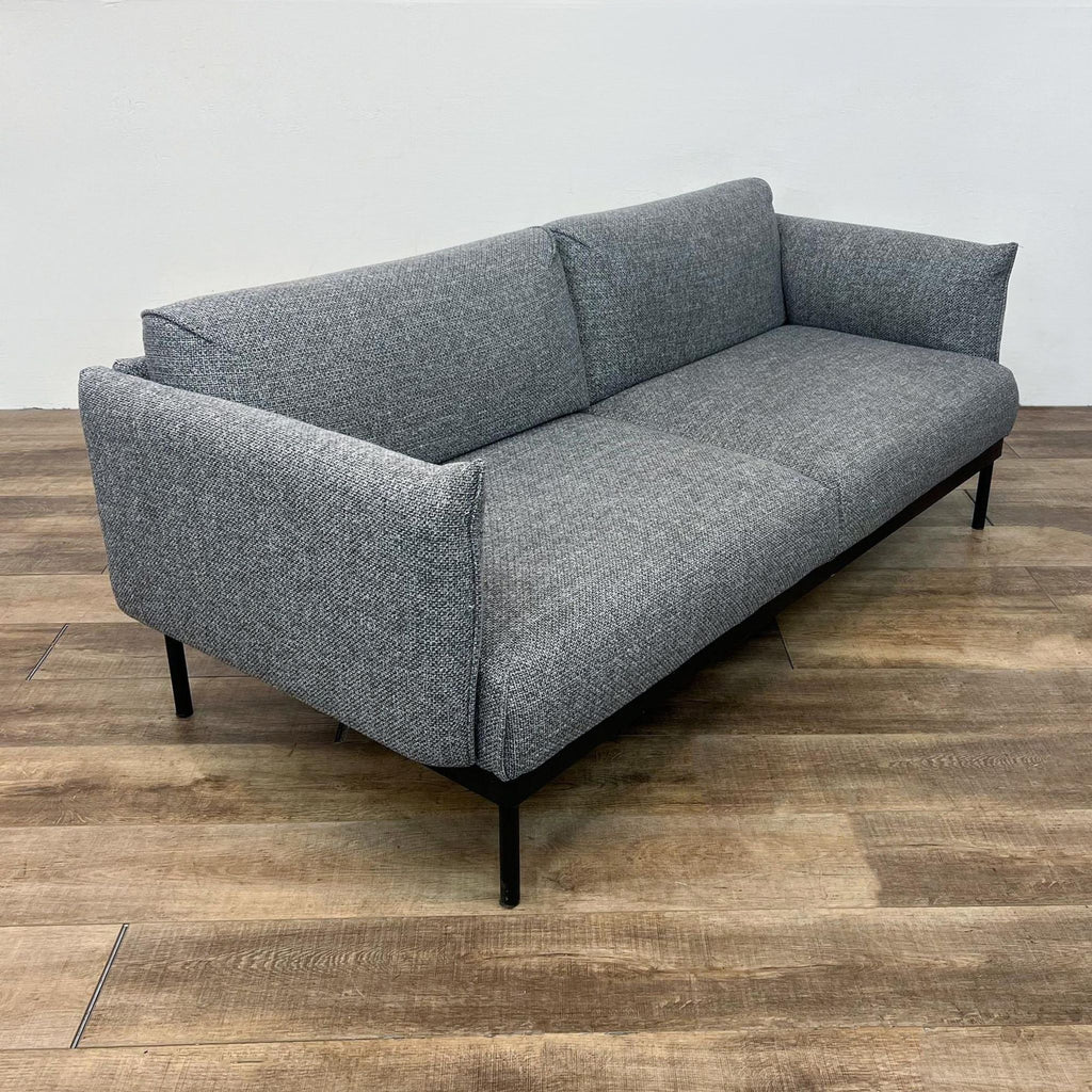 Side view of IKEA 77" gray upholstered loveseat on dark metal legs.  