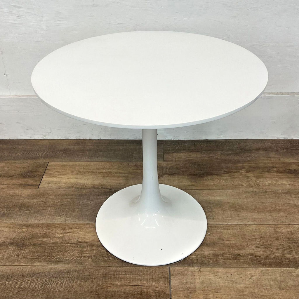 Reperch dining table features a round top and sleek tulip base design.