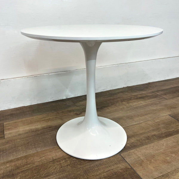 Mid-Century Modern dining table with round wood top, tulip-style metal base.
