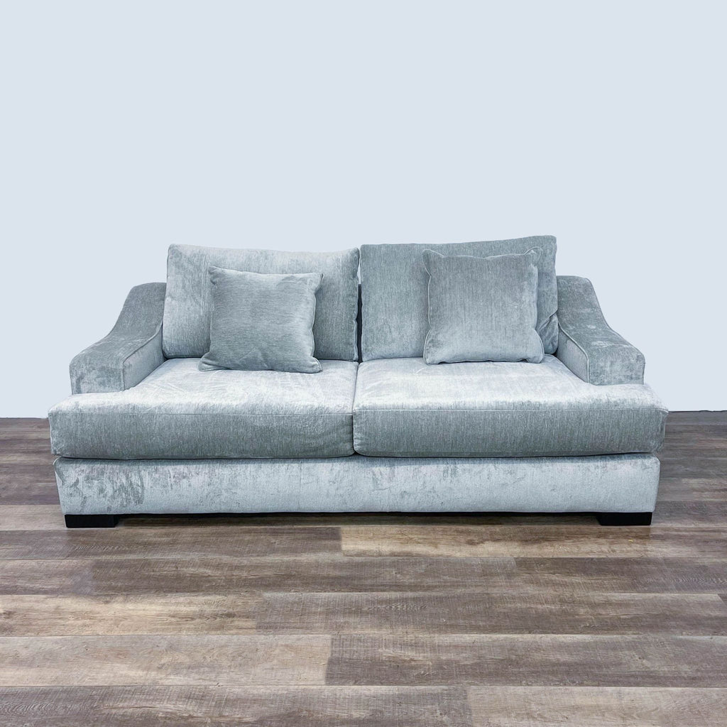 Gray chenille sleeper sofa with plush cushions on wooden floor.