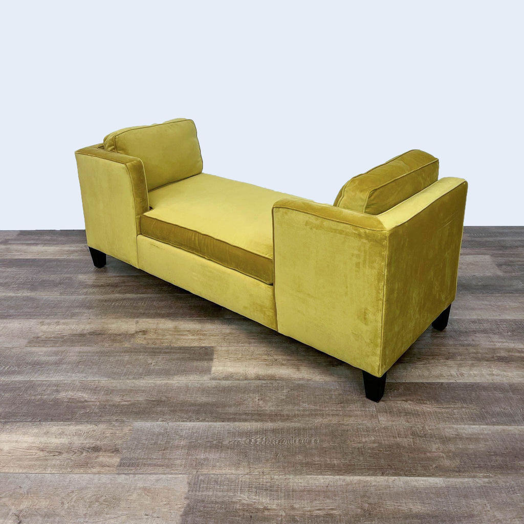 Side view of mustard velvet daybed featuring dark finish feet and pillows.