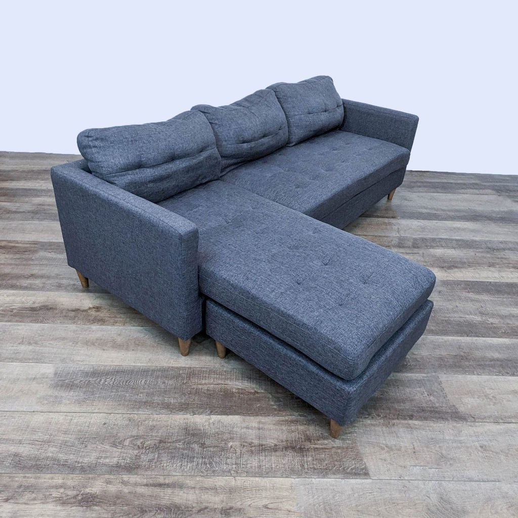 Compact 86-inch tufted sectional featuring tapered feet and a chaise lounge.