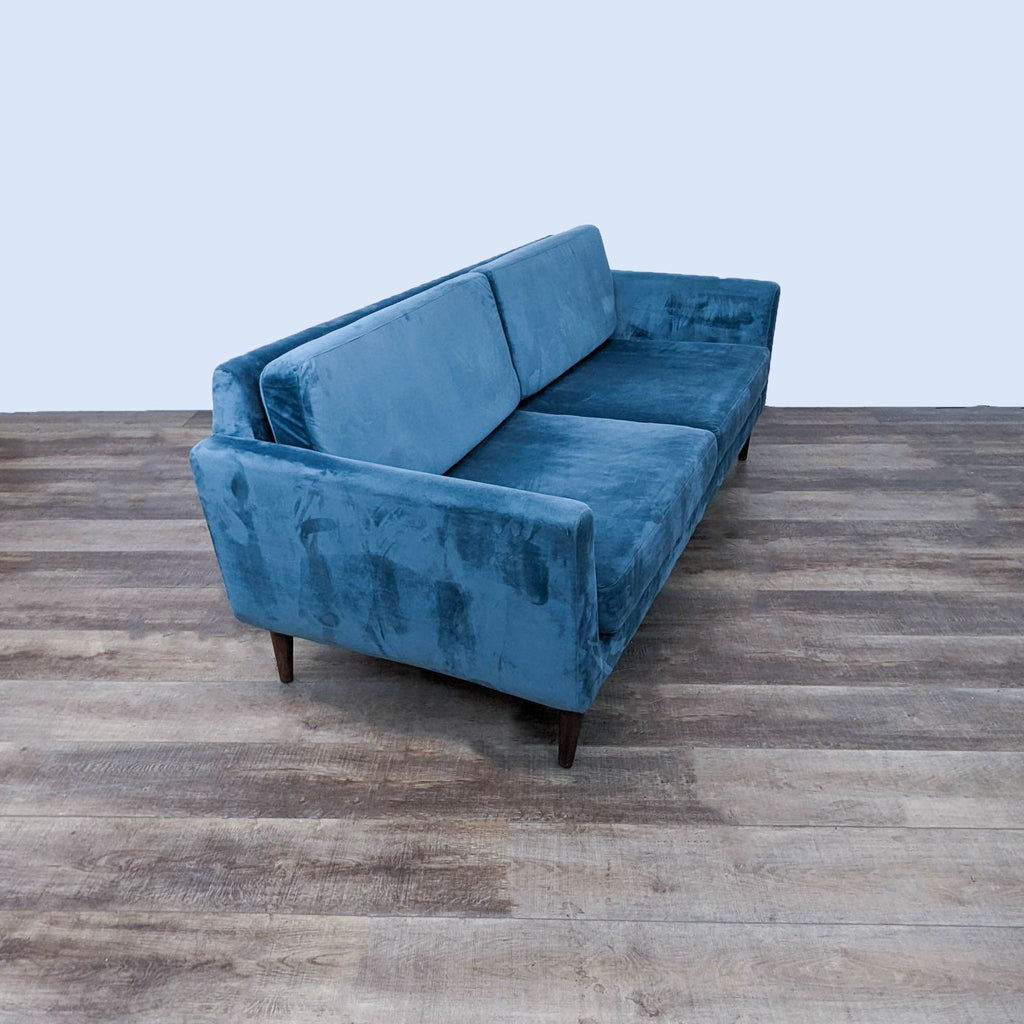 Blue fabric sofa from side showing line design and functional elegance.