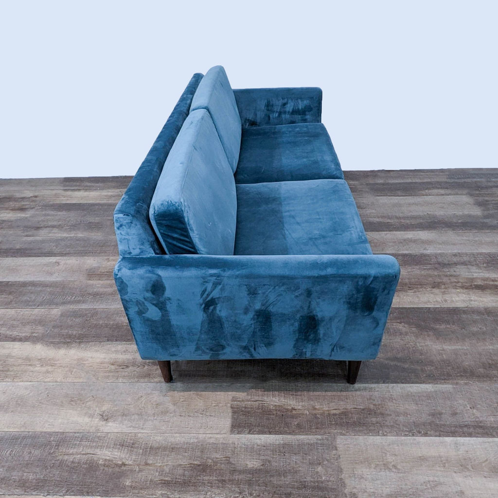 Perspective view of 3-seat sofa with sleek blue fabric and tapered legs.