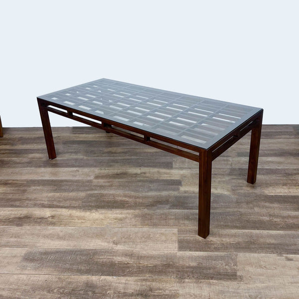 Reperch dining table with glass top, geometric wood design, and pierced apron.