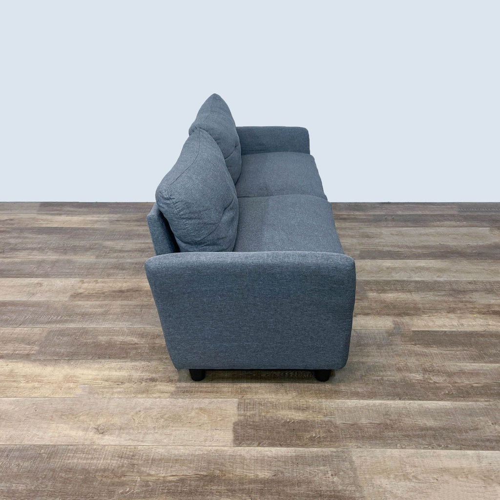 Angled view of a gray loveseat featuring sleek design and dark wooden feet.