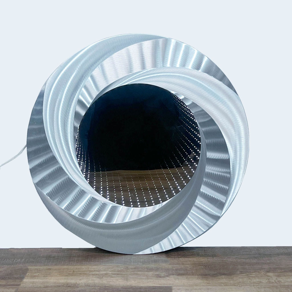 a circular metal sculpture with a metal grid on top.